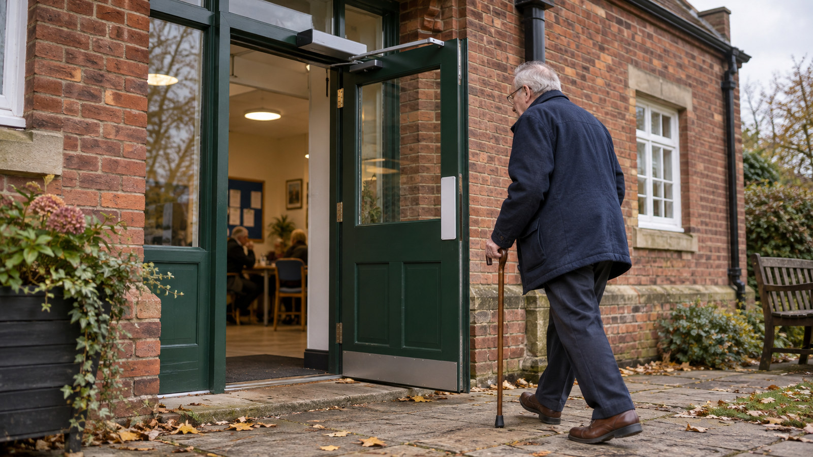Older visitor approaching a powered swing door at a community centre